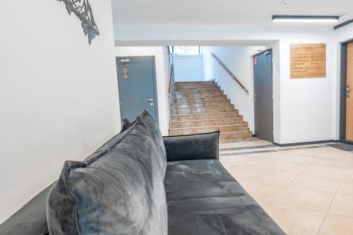 a couch in a living room with stairs at Apartmán Horček, Terchová in Terchová