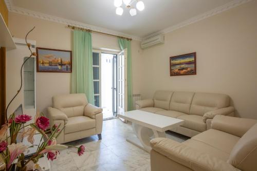 a living room with two couches and a table at Luxury Apartments Montesan in Sveti Stefan