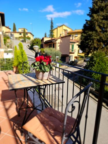 a table with a potted plant on a balcony at Chiantirooms Guesthouse in Greve in Chianti