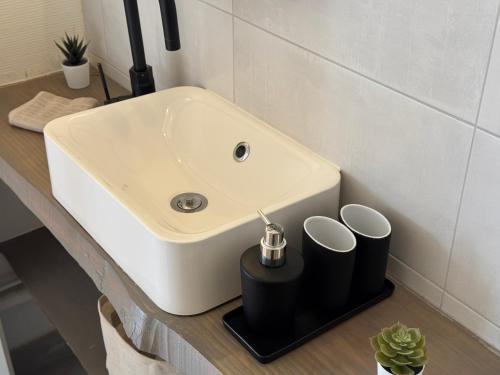 a bathroom sink with two cups on a counter at Bonjour Colmar in Colmar
