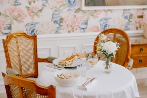 a table with a plate of food and glasses of wine at Hôtel de Toiras in Saint-Martin-de-Ré