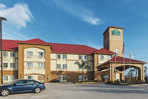 a car parked in front of a building with a clock tower at La Quinta by Wyndham Houston Hobby Airport in Houston