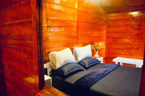 a bedroom with a bed in a wooden wall at Crystal Villa Knuckles in Kandy