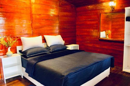 a bedroom with a bed in a wooden wall at Crystal Villa Knuckles in Kandy