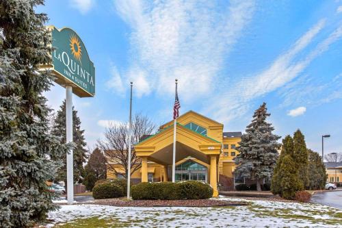 a sign in front of a building with a flag at La Quinta by Wyndham Appleton College Avenue in Appleton