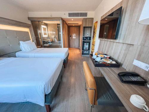 a hotel room with two beds and a table with food at Novotel RJ Praia de Botafogo in Rio de Janeiro