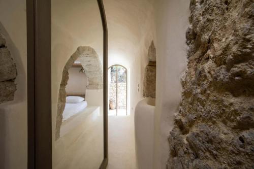 a room with a stone wall and a bedroom at Paleopoli Cave House in Kythira