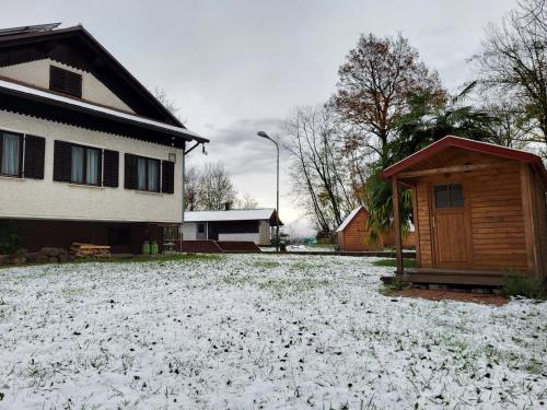 a yard covered in snow next to a house at Koča sredi gozda in Kanal