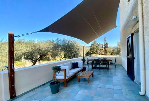 a patio with a couch and a table on a balcony at Villa Boeddu, relax tra mare e campagna in Alghero