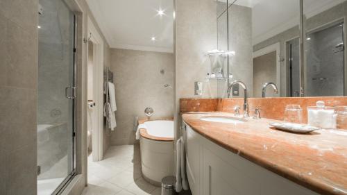 uma casa de banho com um lavatório, um chuveiro e uma banheira em The Petersham em Richmond upon Thames