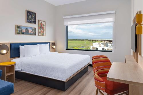 a hotel room with a bed and a window at Hampton By Hilton Guanacaste Airport in Liberia