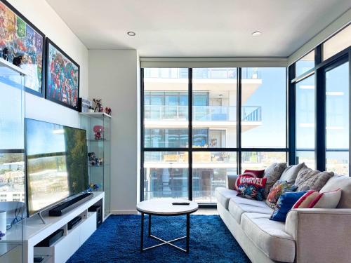 a living room with a couch and a large window at DC vs Marvel Theme ft Arcade Machine Pool Gym Sauna BBQ in Adelaide