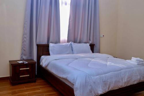 a bedroom with a large bed with a window at Judah Chaim Apartments in Ashaiman