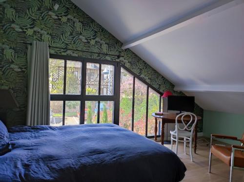 une chambre avec un lit bleu et une fenêtre dans l'établissement Charmante villa, à Villers-sur-Mer