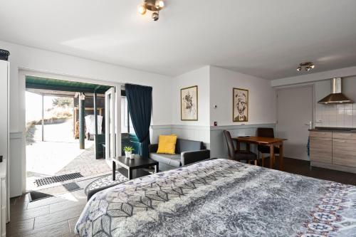 a bedroom with a bed and a desk and a chair at Co's Duyne - Beautiful studio near the dunes of Callantsoog in Callantsoog