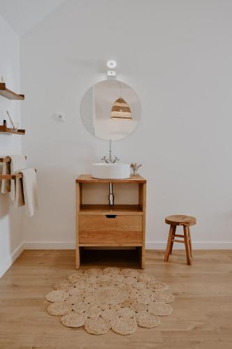 a bathroom with a sink and a table with a mirror at Proche Honfleur Chaleureux Duplex Centre Ville 1 in Beuzeville