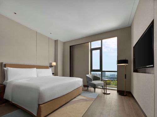 Ένα ή περισσότερα κρεβάτια σε δωμάτιο στο Doubletree By Hilton Yantai Golden Coast Hotel & Suites