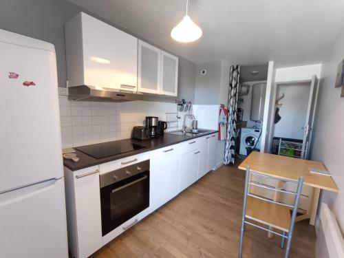 - une cuisine avec des appareils blancs et une table en bois dans l'établissement 3 pièces confort - 6 pers - Pistes - Wifi - Parking - FR-1-445-6, à Montgenèvre