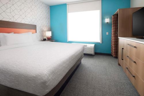 a bedroom with a large bed and a television at Home2 Suites By Hilton Albuquerque Airport in Albuquerque