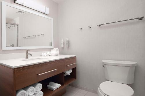 a bathroom with a sink and a toilet and a mirror at Home2 Suites By Hilton Albuquerque Airport in Albuquerque