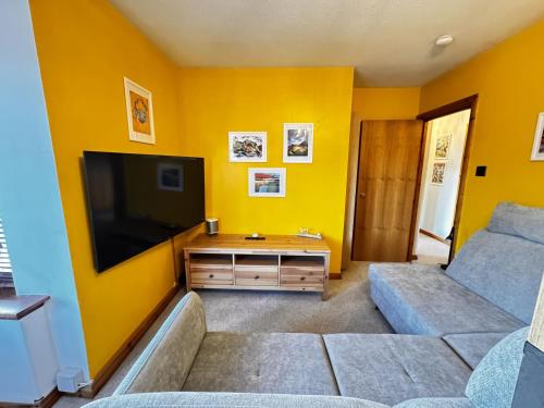 a living room with a couch and a flat screen tv at The Maltings Retreat in Inverkeithing