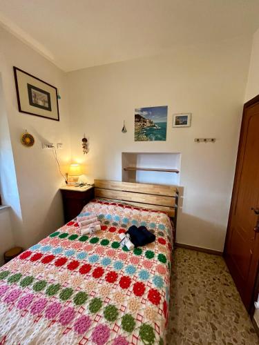 a bedroom with a bed with a quilt on it at LA GINESTRA B&B in Fosdinovo