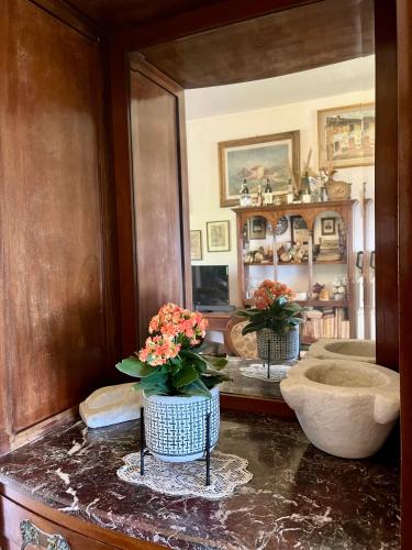 a room with two vases with flowers on a table at LA GINESTRA B&B in Fosdinovo