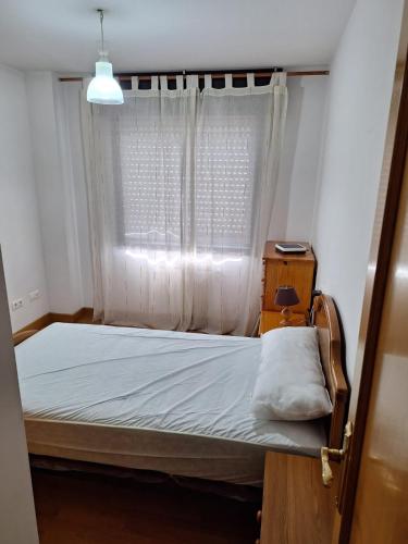 a bed in a room with a window at Apartamento Pose Arteixo in Arteixo