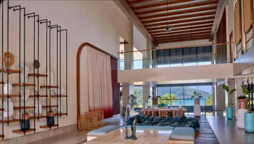 a living room with a couch and a table at Canopy By Hilton Seychelles Resort in Anse a La Mouche