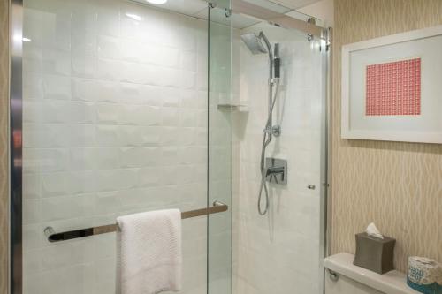a bathroom with a shower with a glass door at Marriott St. Louis Airport in Edmundson