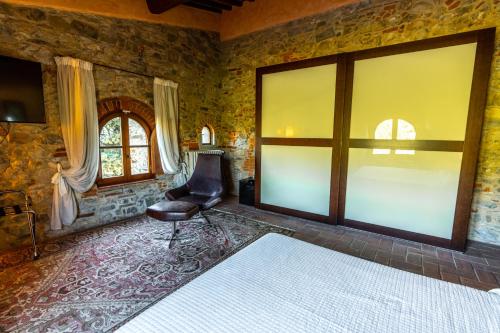 a bedroom with a bed and a chair and a window at Agriturismo Sottotono in Carmignano