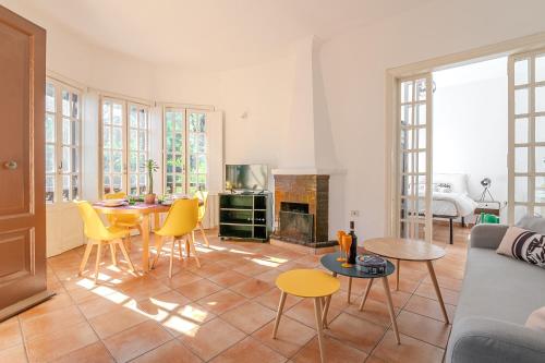 a living room with a couch and a table and chairs at Roseto Villa Dream - Free parking - Near the BEACH - 400 mq garden in Fregene