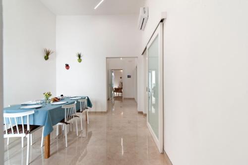 a dining room with blue tables and white chairs at Li Cori House - Lecce Selection in Trepuzzi