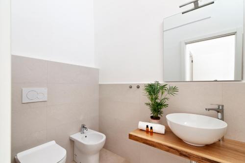 a bathroom with a sink and a toilet and a mirror at Li Cori House - Lecce Selection in Trepuzzi