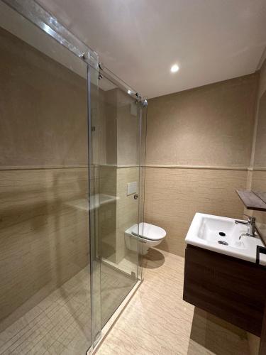 a bathroom with a shower and a toilet and a sink at L'opera luxury apartment Sidi Maarouf - Near Casa Nearshore in Casablanca