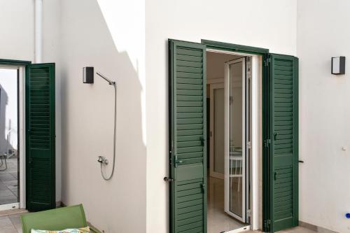 a bathroom with green shutters and a glass door at Li Cori House - Lecce Selection in Trepuzzi