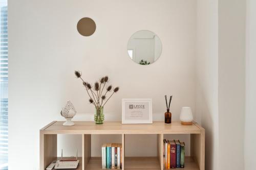 a table with books and a mirror in a room at Li Cori House - Lecce Selection in Trepuzzi