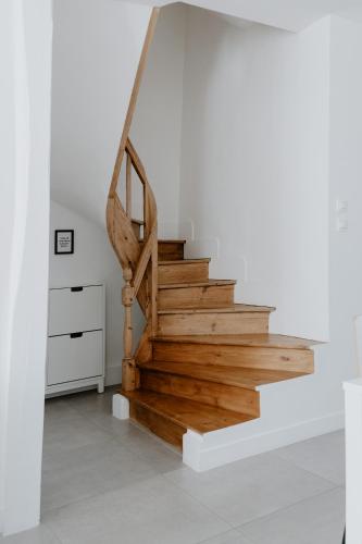 a staircase in a white room with wooden steps at Proche Honfleur Chaleureux Duplex Centre Ville 1 in Beuzeville