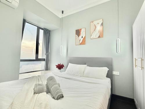 a white bedroom with a large bed and a window at R&F Seine Region in Johor Bahru