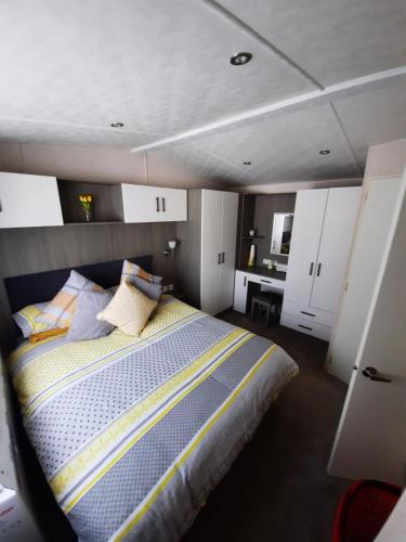 a bedroom with a bed and a desk in it at Sunset retreat caravan with large wrap around decking in Newquay
