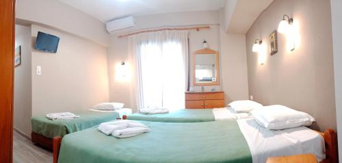 una stanza con due letti con asciugamani sopra di Prosforio Rooms a Ouranoupoli
