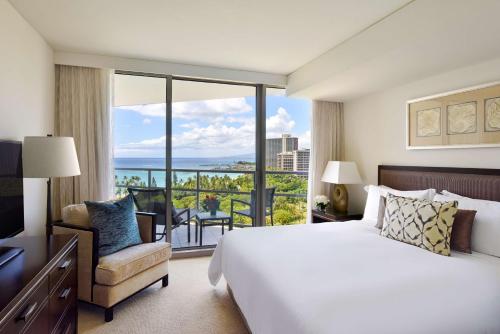 ホノルルにあるKa Laʻi Waikiki Beach, LXR Hotels & Resortsの大きなベッドとバルコニーが備わるホテルルームです。