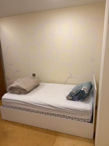 a bed in a room with a white wall at Rova Hotel in Baku