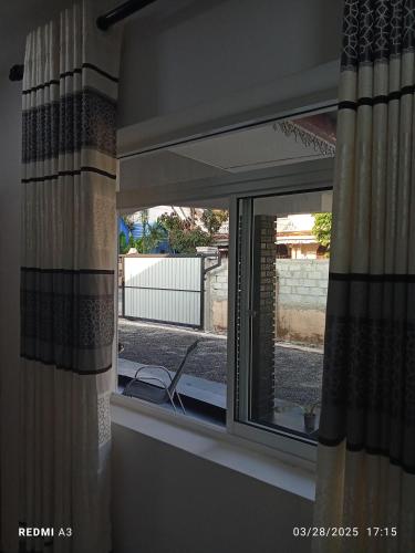 a window with curtains and a chair in a room at Solaces transit residence in Liyanagemulla