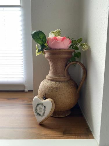a vase with flowers and a heart on the floor at Gemütlicher Glücksplatz in Frielendorf