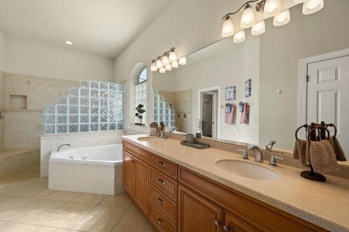 a bathroom with a tub and a sink and a bath tub at Villa Somada in Cape Coral