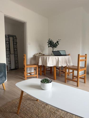 un salon avec une table et des chaises blanches dans l'établissement Appartement 75 metres carres proche gare et tram, à Montpellier