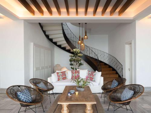 a living room with a white couch and a staircase at Swissôtel Living Bodrum in Bodrum City