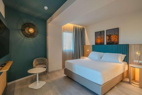 a bedroom with a bed and a table and a chair at Terradamari Resort & Spa Marina di Modica,Tapestry by Hilton in Marina di Modica