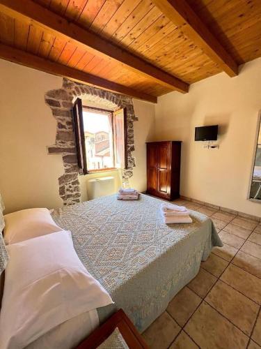 a bedroom with a bed in a room with a window at La Vecchia Torre in Bosa